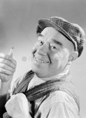 Portrait of a man in a flat cap smoking  1949.