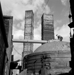 A worker on top of pottery kiln in the yard of Wheatley’s Quarries  Stoke on Trent.