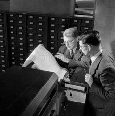 Two computer programmers watch results coming off machine   1954.
