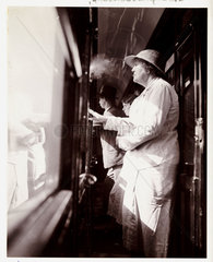 Woman smoking in a train corridor  1936.