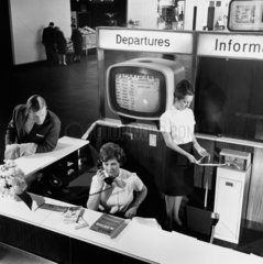 Information desk at Manchester Airport including woman with ticker tape  1965.