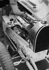 Robert Aumaitre working on the engine of a Bugatti  Berlin  1933.