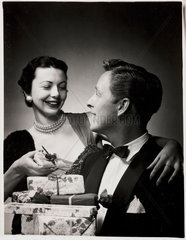 Couple with Christmas presents  c 1958.