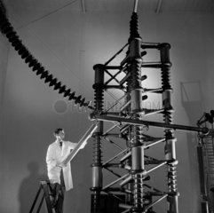Engineer working on high voltage circuit breaker   1954.