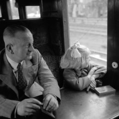 Father sitting with his daughter during a train journey  1950.