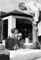 Boy in a toy car  c 1930s.