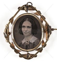 Small portrait of a woman contained in a brooch  mid-late 19th century.