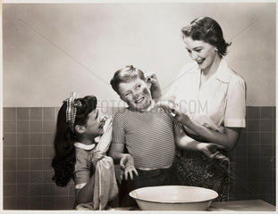 Mother washing her son's face  c 1958.