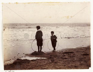 Two boys with hoops on the seashore  c 1905.