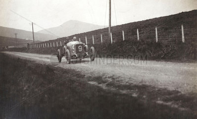 Racing car on a country road  c 1912.