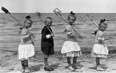 Four children at the seaside  c 1910s.