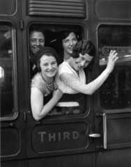 A group of young women looking out of a railway carriage  3 July 1931.