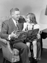Man reading a story to a child  1949.