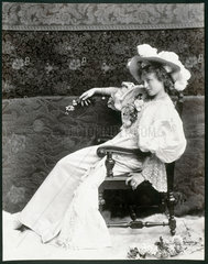 Young woman wearing an elaborate dress and hat  c 1890s.