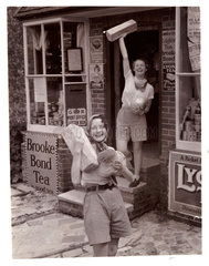 Two women carrying loaves of bread  c 1935.