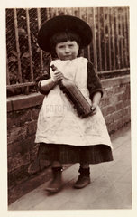 Small girl carrying a bottle  1898.