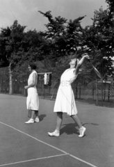 Woman tennis player about to serve in a gam