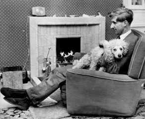 Ally McLeod  Scottish footballer  relaxing in a chair with his dog  8 January 1962.
