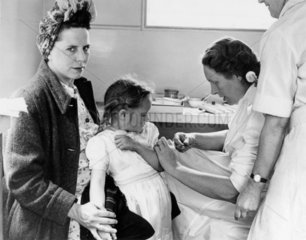 Female doctor immunising a small girl against diphtheria  6 July 1949.