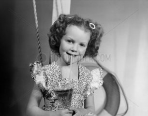 Little girl drinking juice through a straw  1950.