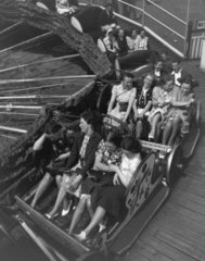 Young women enjoying a fairground ride  c 1