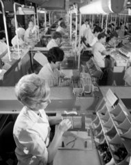 Computer manufacture : long shot of women on integrated circuit production.