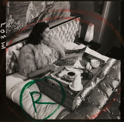 Woman having breakfast in bed  1950s.