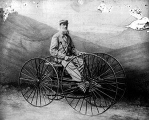 Man sitting on four-wheeled velocipede  19th century.