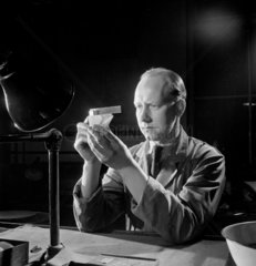 Optical worker checks the angle of a prism  1953.