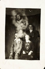 Family group with two 'spirits'  c 1920.