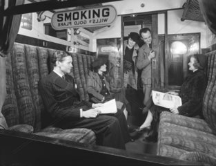 Passengers in a first class railway carriage smoking compartment  1936.