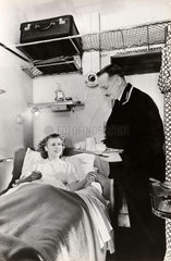 Passenger being served breakfast in bed in a sleeping car  c 1937.