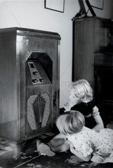 Two children listening to a GEC radio receiver  c 1930.