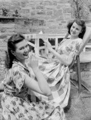 Two women smoking in the garden  c 1948.
