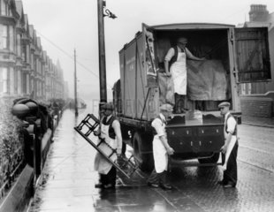 Removal men unloading from a road-rail container  London  1931.