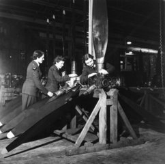 Women repairing damaged aircraft propellers