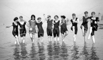 Line of women in bathing costumes paddling