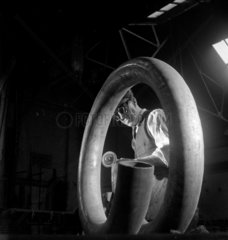 A worker grinds a coiled steel tube at Talbot Stead Steel Tubes  Walsall  1948.