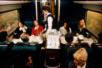 Stewardess serving coffee to smartly dressed passengers  1975-1985.