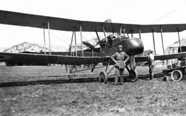 Pilot standing before his aeroplane  c WWI.