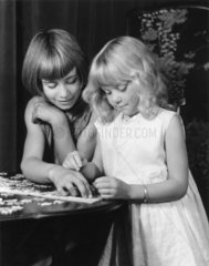 Two girls doing a jigsaw  c 1930s.