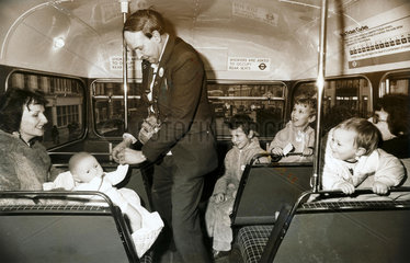 Bus conductor collecting a fare from a doll  1982.