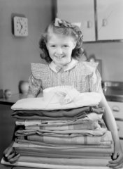 Girl carrying a pile of laundry  1950.