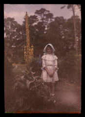 Girl standing in a garden  1908.