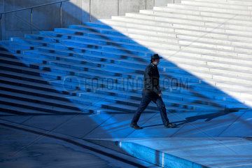 Tallinn  Estland  ein Mann mit Hut laeuft im Blaulicht ueber den Freiheitsplatz