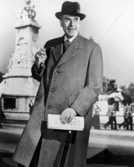 Smartly-dressed man in a long coat  1940s.