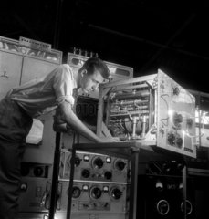 A technician works on an aerial tuning unit   at Mullards  1950.