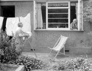 Elderly woman hanging out the washing  1955.
