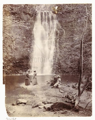 Women at the foot of a waterfall  c 1905.