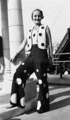 Woman modelling a polka dot trouser suit  c 1930s.